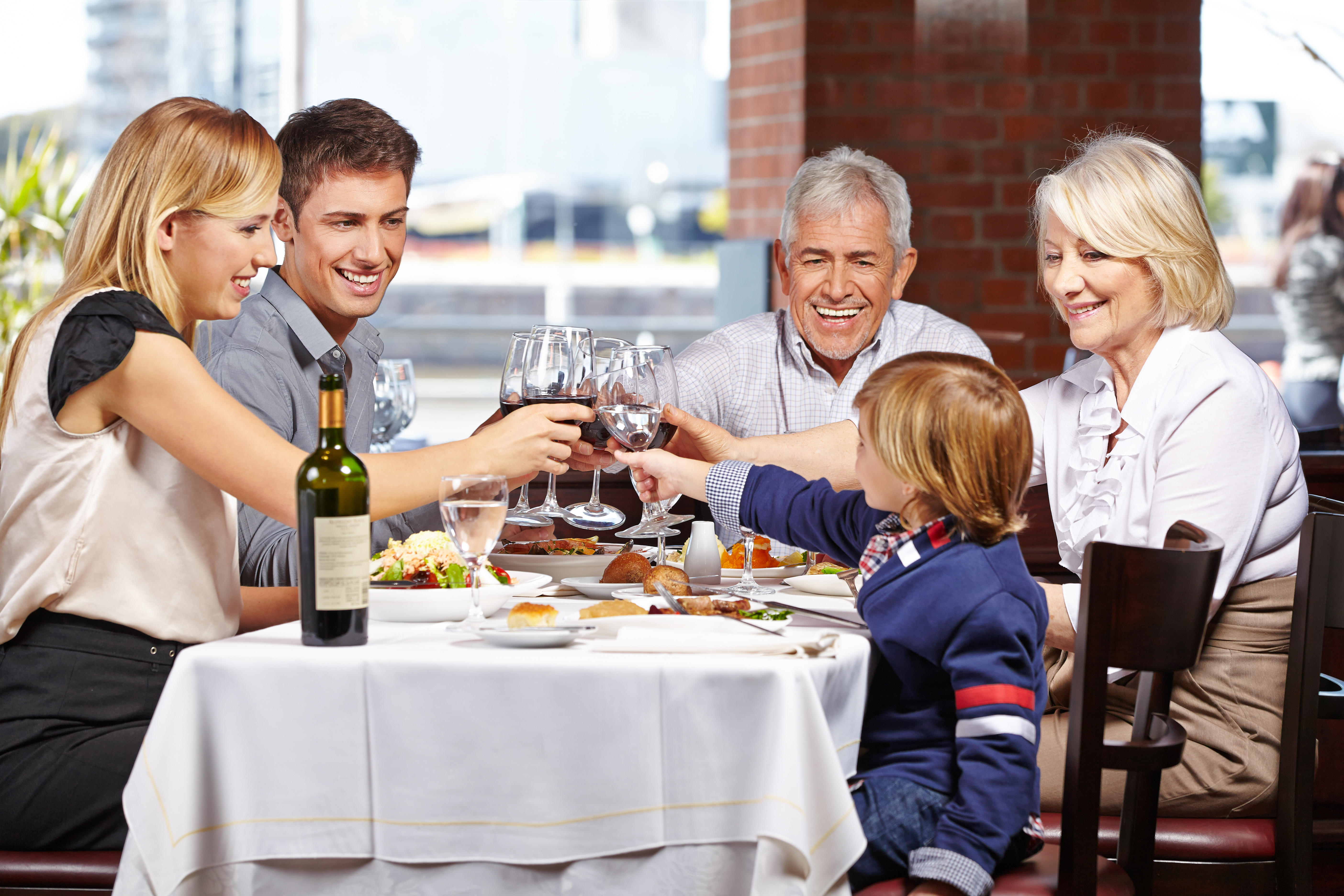 Проведенными в кругу семьи в. Семья за столом. Счастливая семья за столом. Семья обедает в ресторане. Семья за праздничным столом.